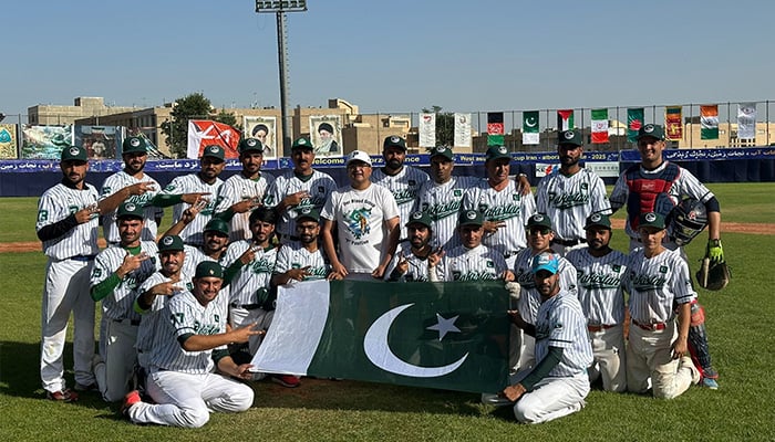 Pakistani baseball players pose for group photo with national flag after advancing to West Baseball Cup final in Karj, Iran. — Reporter
