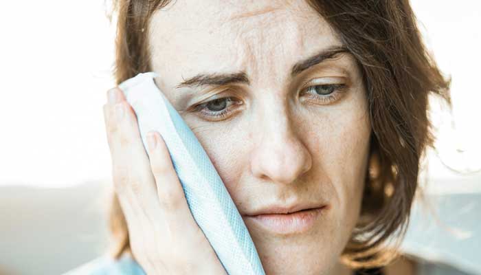 Representational image of a woman experiencing toothache. — Unsplash