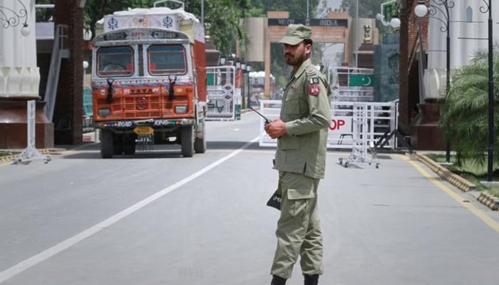 A paramilitary soldier stands guard as a truck carrying wheat crosses into Pakistan from India, at the Wagah border. — Reuters/File