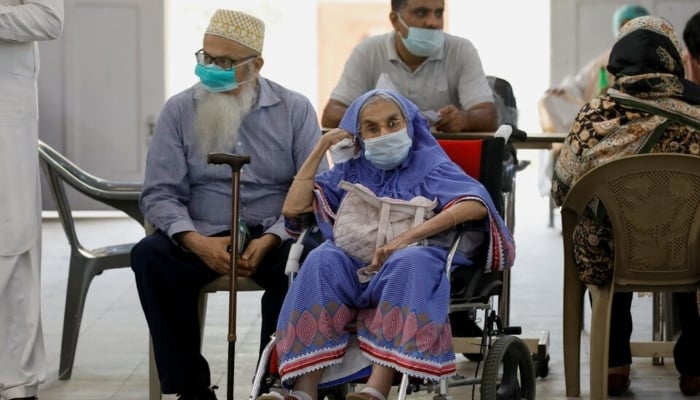 Residents wait for their coronavirus disease (COVID-19) vaccine doses, at a vaccination centre in Karachi, April 2, 2021. — Reuters