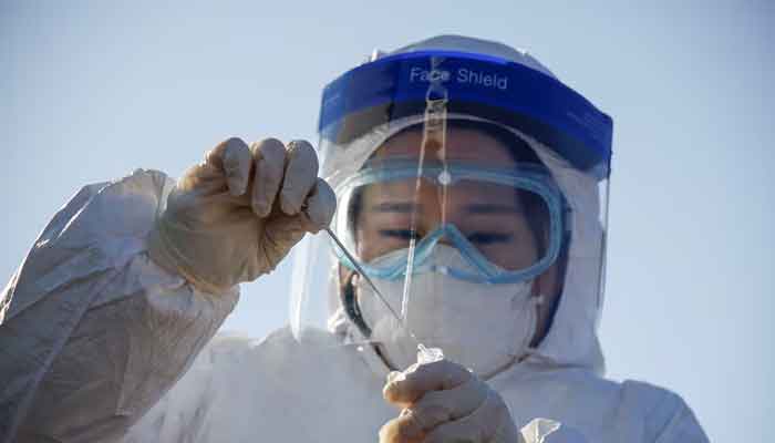 A member of the medical personnel works at a coronavirus disease (Covid-19) testing site which is temporarily set up at a railway station in Seoul, South Korea, December 15, 2020. — Reuters