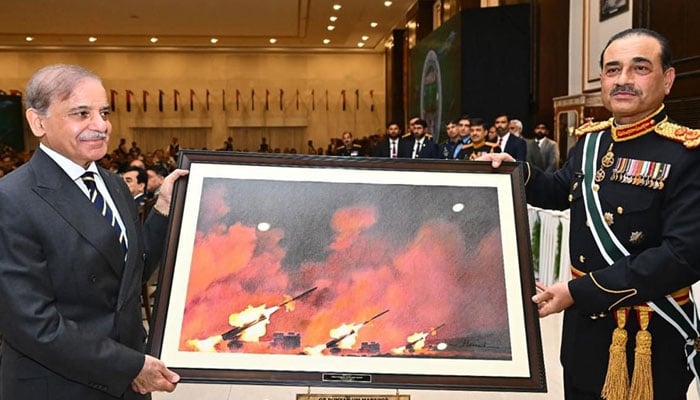 Prime Minister Shehbaz Sharif (left) presents a painting about war to  Field Marshal Asim Munir. — ISPR