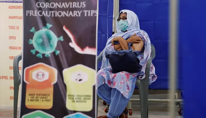 A woman sits in a waiting area after having her first dose of COVID-19 vaccine in Karachi. — Reuters/File