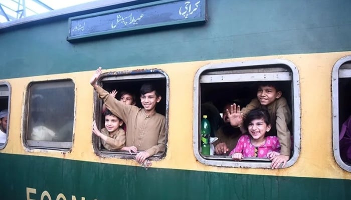 Children waving after getting on board a train at Cantt Railway Station, Karachi on April 7, 2024. — APP
