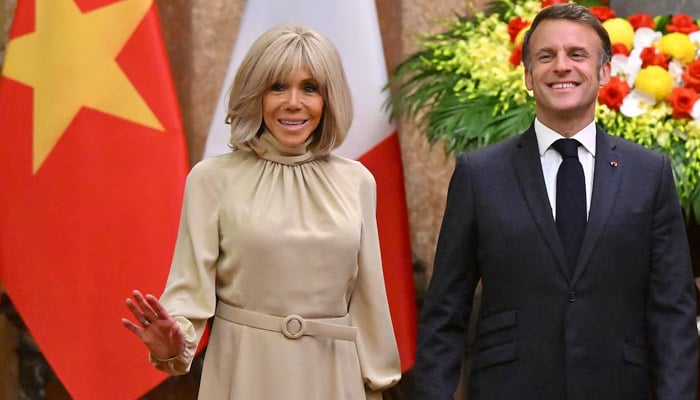 Frances President Emmanuel Macron and his wife Brigitte Macron react as they pose for photos during a meeting at the Presidential Palace in Hanoi on May 26, 2025. — Reuters