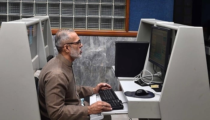 A stockbroker monitors share prices during a trading session at the PSX in Karachi, January 21, 2025. — INP