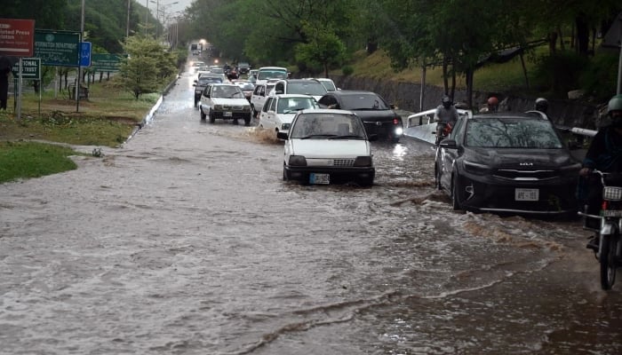 Vehicles heading through stagnant rainwater has accumulated on the road near zero point in the federal capital after strong precipitation, Islamabad, May 24, 2025. - App