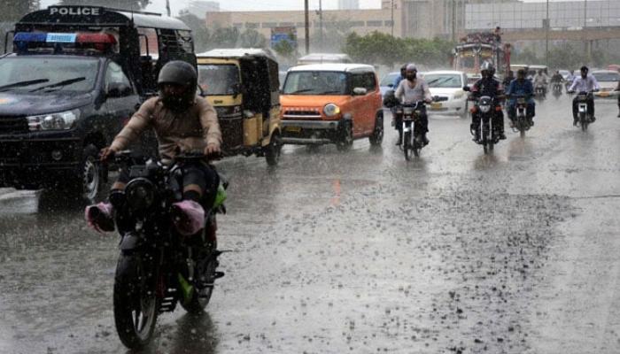 Commuters are passing through a road during heavy downpours of monsoon season, at Sharea Faisal road in Karachi on, July 9, 2024. — PPI