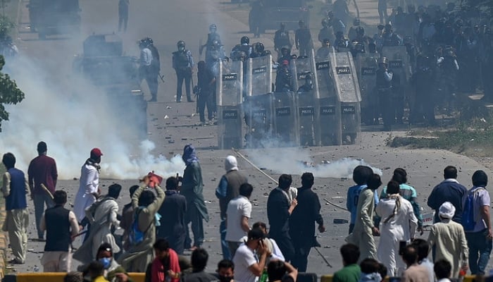 In this photo, taken on May 10, 2023, supporters of former prime minister Imran Khan clash with policemen during a protest against the arrest of their leader, in Islamabad. — AFP