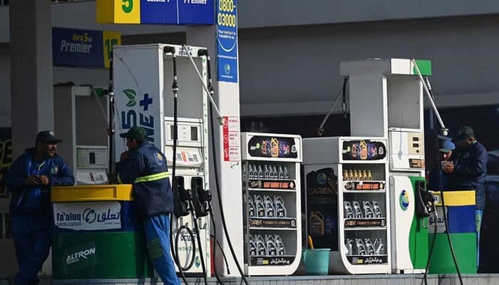 Employees at a fuel station wait for customers in Islamabad. — AFP/File