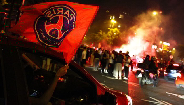 Paris St Germain fans wave a flag out of a car window after winning the Champions on May 31, 2025. — Reuters.