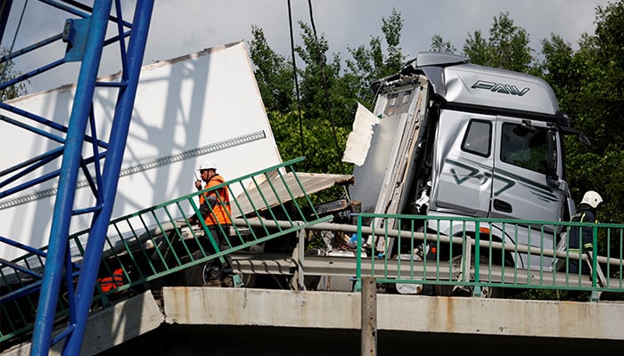 Specialists of emergency services gather near a damaged truck at the scene, after a road bridge collapsed onto railway tracks derailing an approaching train in the Bryansk region, Russia, June 1, 2025. — Reuters