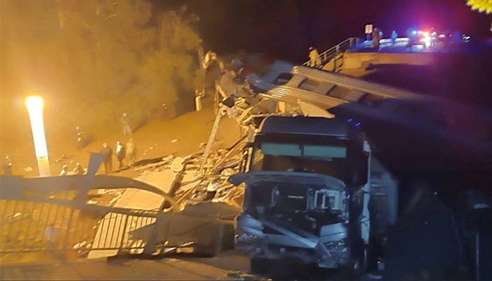A view shows a damaged bus and a train carriage at the scene, after a road bridge collapsed onto railway tracks in the Bryansk region, Russia, in this image released June 1, 2025. — Reuters