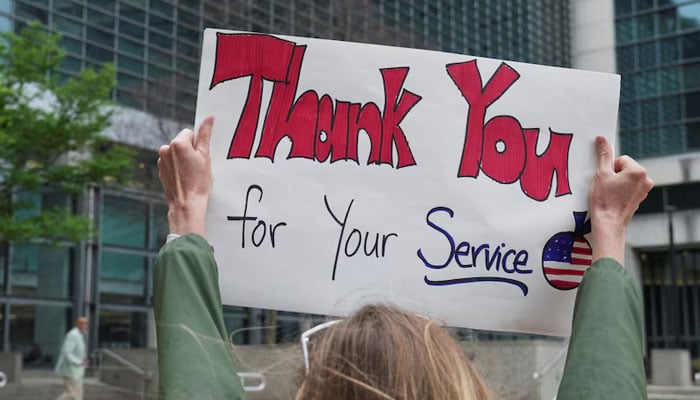 Demonstrators hold up signs of support outside of the Sam Nunn Atlanta Federal Center, on April 2, 2025. — Reuters