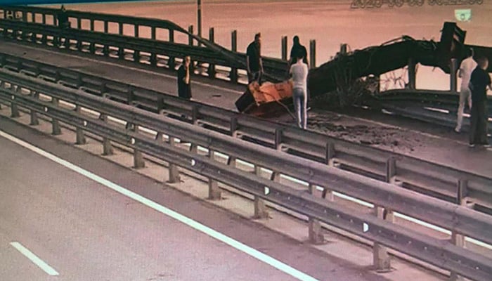 This handout image released by the Ukrainian Security Service on June 3, 2025, allegedly shows people inspecting damage to the Kerch Bridge connecting Crimea with Russia following a special operation carried out by the Ukrainian Security Service, amid the ongoing Russian-Ukrainian conflict. — AFP