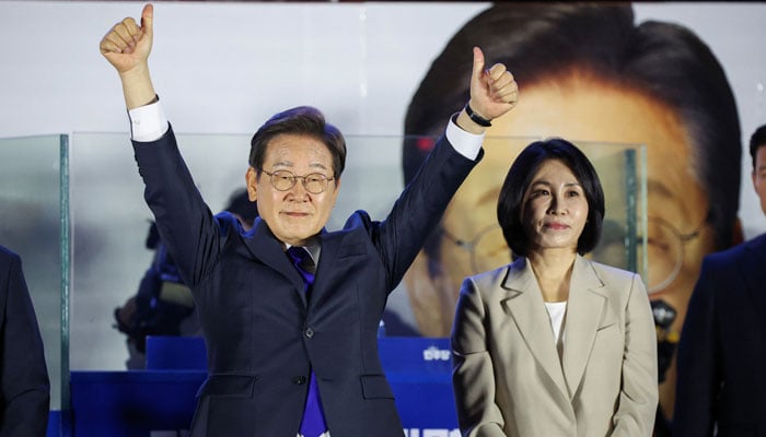 Lee Jae-myung, the presidential candidate for South Koreas Democratic Party, gestures while standing next to his wife Kim Hye-kyung, as he greets his supporters in front of the National Assembly in Seoul, South Korea, June 4, 2025. — Reuters