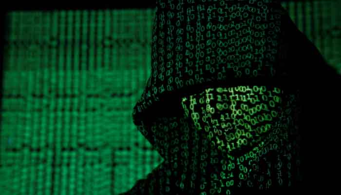 A projection of cyber code on a hooded man is pictured in this illustration picture taken on May 13, 2017. — Reuters