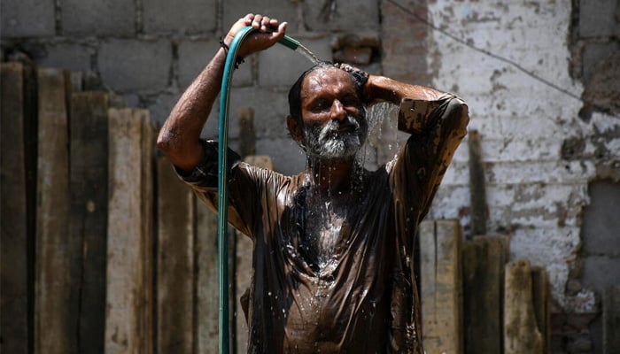 A man cools off with a water hose during a hot summer day in Hyderabad, May 24, 2024. — Reuters