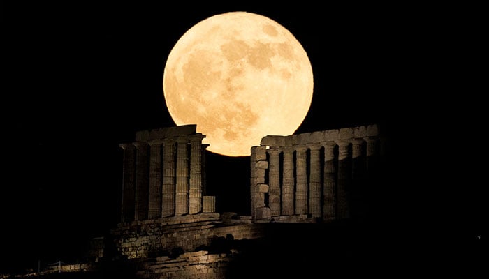 A full moon known as the Strawberry Moon rises behind the Temple of Poseidon, in Cape Sounion, near Athens, Greece on June 15, 2022. — Reuters