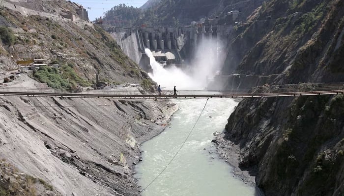 Labourers walk on a bridge near the 450-megawatt hydropower project located at Baglihar Dam on the Chenab river which flows from Indian Illegally Occupied Jammu and Kashmir into Pakistan on October 10, 2008. — Reuters