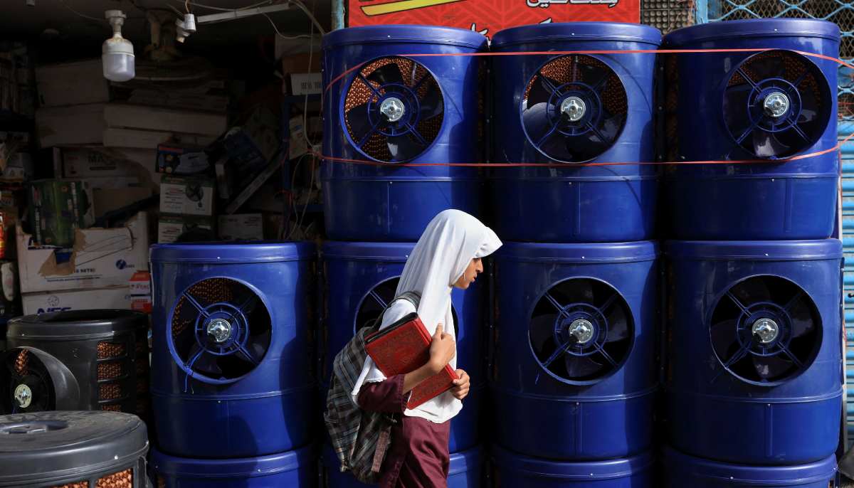 A girl walks past a display of locally manufactured evaporative air coolers for sale, outside a shop, during a hot summer day, in Karachi on May 27, 2025. — Reuters