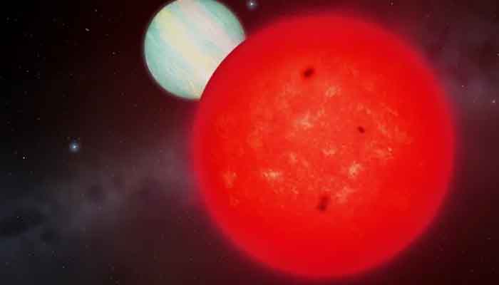 An artists impression of the red dwarf star TOI-6894 (foreground) and its giant planet orbiting in the background. — University of Warwick