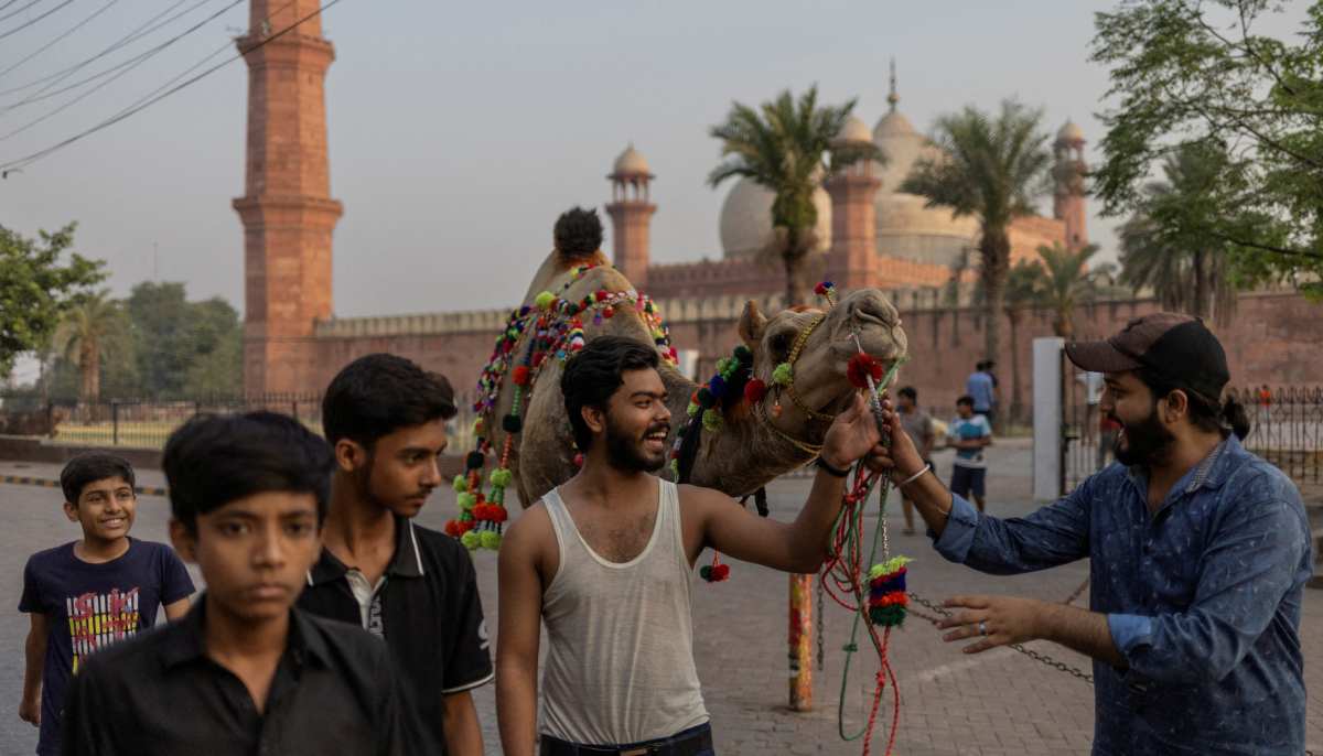 Bakhtawar, 23, and Irtaza, 22, parade a sacrificial camel, decorated with celebratory garlands, near Badshahi Mosque in preparation for the Eid al-Adha holiday in Lahore on June 6, 2025. — Reuters