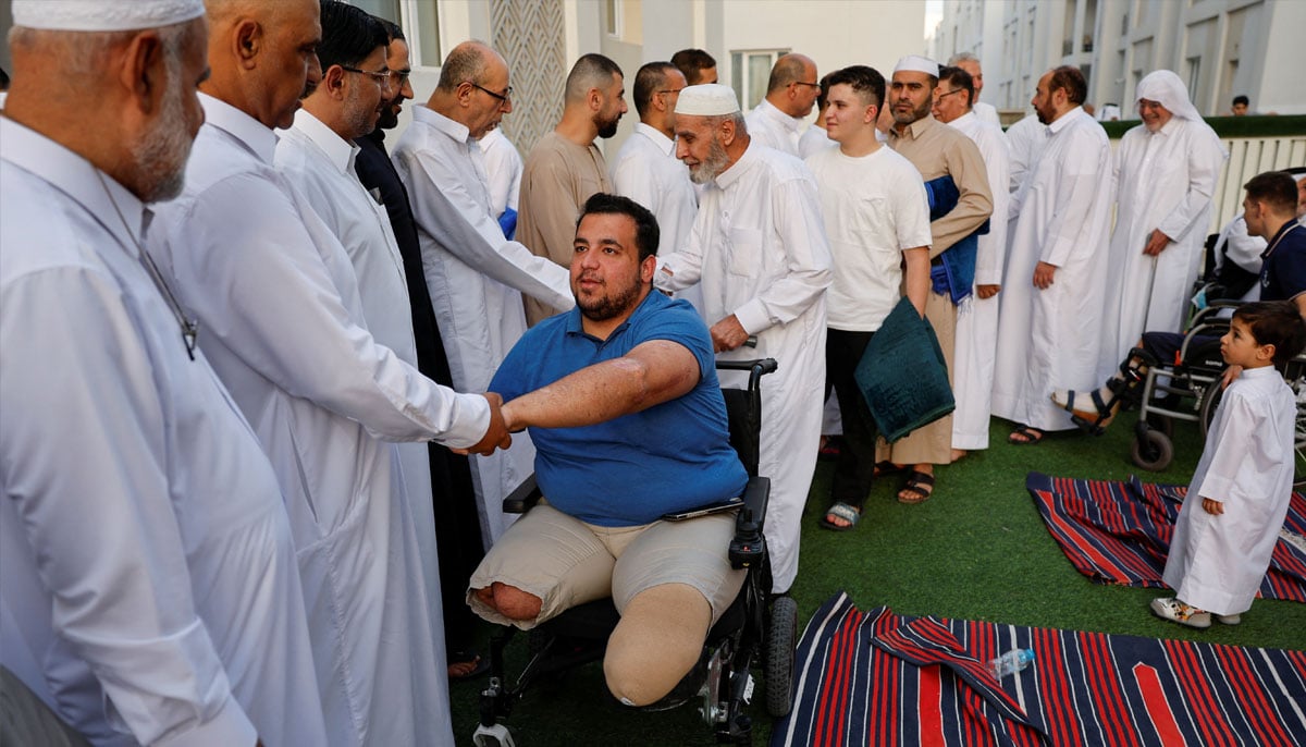 A Palestinian from Gaza injured in the Israel-Hamas conflict greets a fellow as they attend Eid ul Adha prayer at Al Thumama Complex, in Doha, Qatar, June 6, 2025. — Reuters