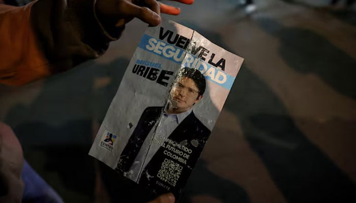 A person holds a campaign poster at the area where Colombian Senator Miguel Uribe Turbay of the opposition Democratic Centre party, was shot during a campaign event, in Bogota, Colombia, June 7, 2025. — Reuters