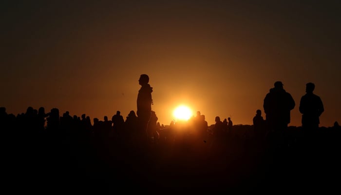 Revellers watch the sun set on the eve of the summer solstice at the Stonehenge stone circle, in Amesbury, Britain, June 20. — Reuters