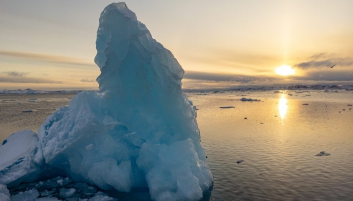 This aerial view shows the sun setting behind icebergs and ice floating in the water off Nuuk, Greenland, on March 7, 2025. — AFP