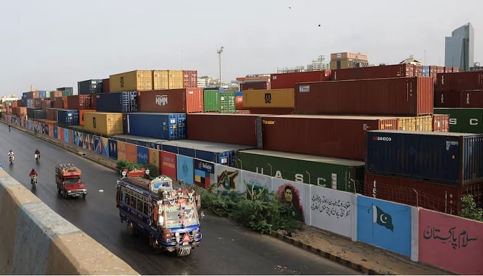 Vehicles move past a shipping container yard along a road in Karachi on June 10, 2025. — Reuters