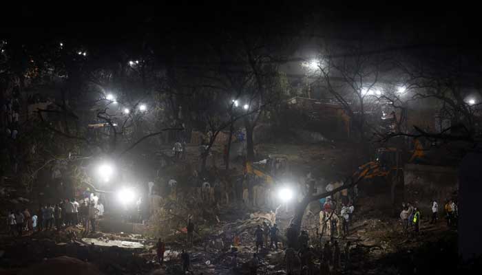 People gather as rescue team members work at the site where an Air India Boeing 787 Dreamliner plane crashed in Ahmedabad, India, June 12, 2025. — Reuters