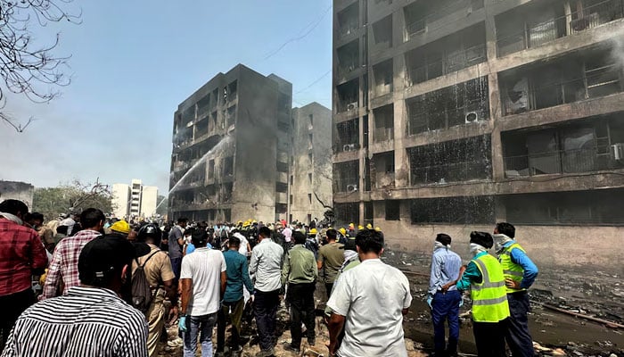 People gather near the site where an Air India plane crashed in Ahmedabad, India, June 12, 2025. — Reuters