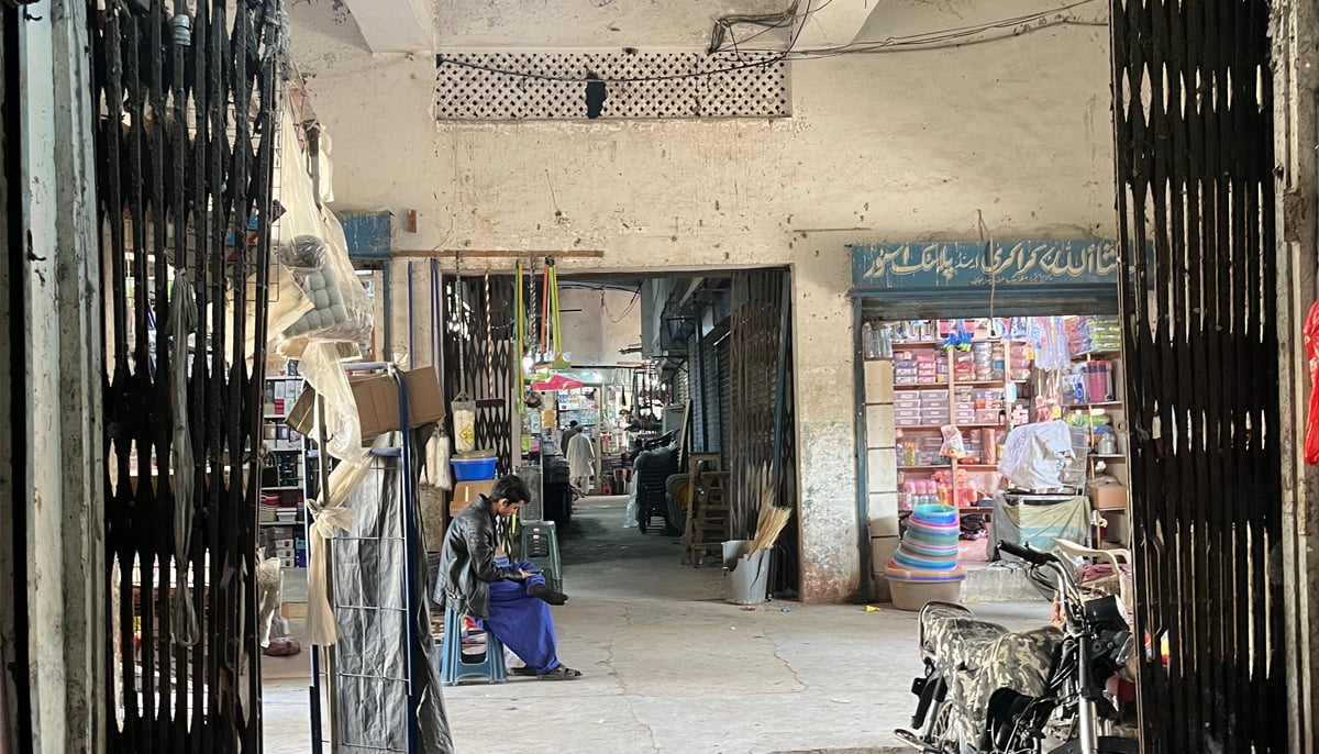 A shopkeeper is seen seated next to his shop at the market. — Photo by author