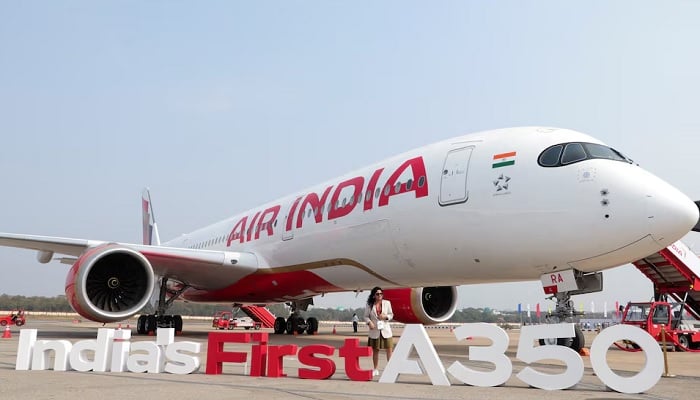 A woman stands next to the Air India Airbus A350 aeroplane, displayed at Wings India 2024 aviation event at Begumpet airport, Hyderabad, India, January 18, 2024. —Reuters