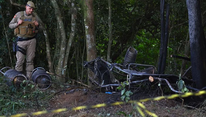 A military police officer stands next to the wreckage of a hot air balloon that caught fire and crashed. — AFP/File