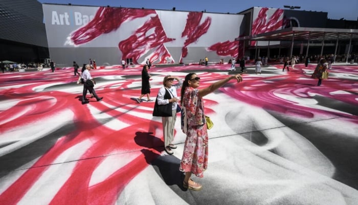 Visitors walk on the artwork Choir by the German artist Katharina Grosse at the Art Basel fair entrance. — AFP/File