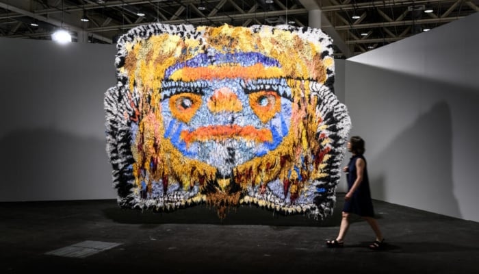 A visitor walks past Gobbler by Caroline Achaintre at Art Basel. —AFP/File