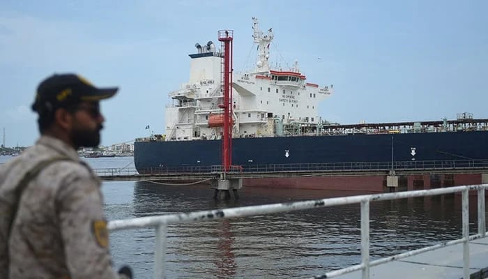 A security personnel stands guard near a Russian cargo ship carrying crude oil docked at the Karachi port in Karachi on June 28, 2023. — AFP