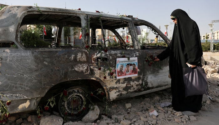 A woman looks at an ambulance burned by Israeli attacks on a street, during the Iran-Israel conflict, in Tehran, Iran, June 23, 2025. — Reuters