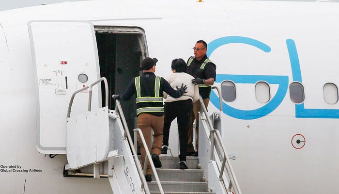 A migrant detained by US Immigration and Customs Enforcement (ICE) and law enforcement officers boards a plane after being transferred from an ICE detention facility, at Gary/Chicago International Airport, in Gary, Indiana, US, June 20, 2025. — Reuters