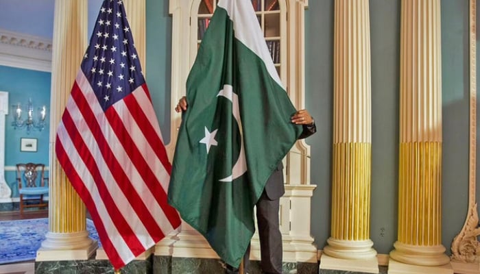 A State Department contractor adjusts a Pakistan national flag at the State Department in Washington on February 19, 2015. — Reuters