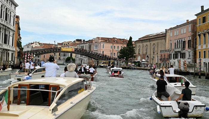 The boat Moa transporting Amazons founder Jeff Bezos is escorted on the Grand Canal on his wedding day in Venice on June 27, 2025. — AFP