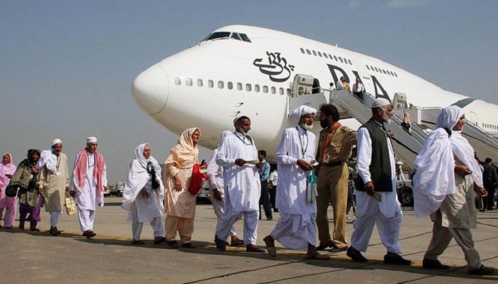 Pilgrims walk in line as they prepare to board a Pakistan International Airlines special Hajj pilgrimage flight bound for Saudi Arabia at the Allama Iqbal International airport in Lahore. — AFP/File