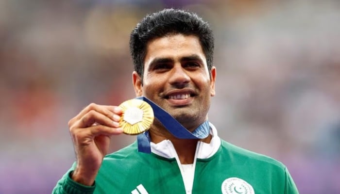 Gold medallist Arshad Nadeem of Pakistan celebrates at Paris 2024 Olympics with his medal on the podium — Reuters