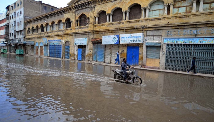 A motorcyclist is wading through stagnant water at Old City area in Karachi on June 29, 2025.  — PPI