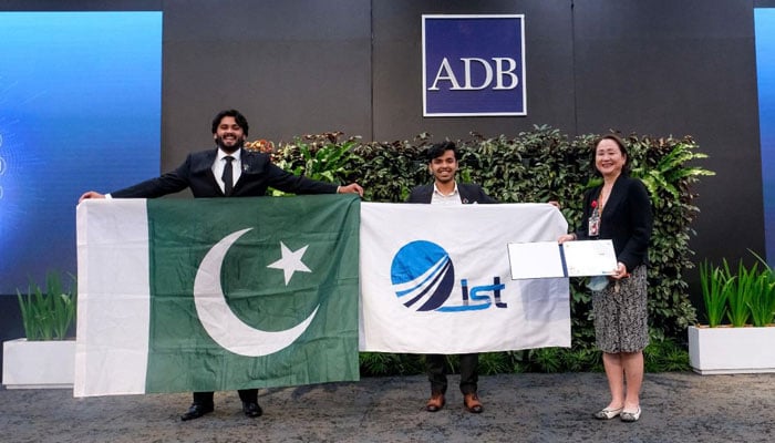 Ahmed Iqbal (left) and Abdullah Asif pose with Pakistans national flag after winning the Best AI Use Case award at the APAC Solution Challenge in Manila, Philippines, on June 26, 2025. — Reporter