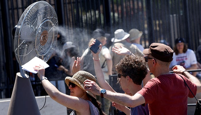 Tourists stand in front of a cooling fan installed outside the Colosseum in during the heatwave in Rome, Italy, June 30, 2025. — Reuters