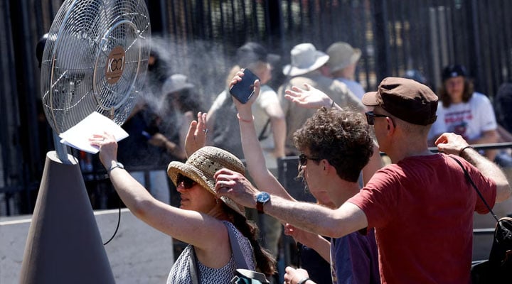Tourists stand in front of a cooling fan installed outside the Colosseum in during the heatwave in Rome, Italy, June 30, 2025. — Reuters